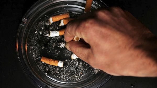 Мужчина тушит сигарету, фото из архива - Sputnik Азербайджан