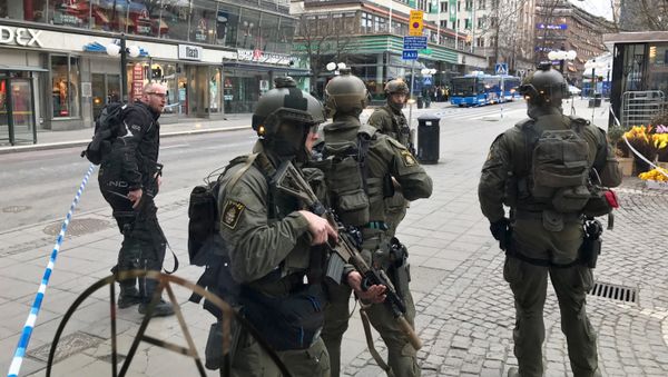 Полицейские в центре Стокгольма после наезда грузовика на людей на улице Дроттнинггатан. 7 апреля 2017 года - Sputnik Азербайджан