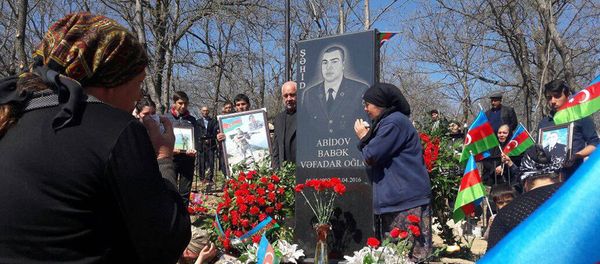Близкие возле могилы шехида Бабека Абидова - Sputnik Азербайджан