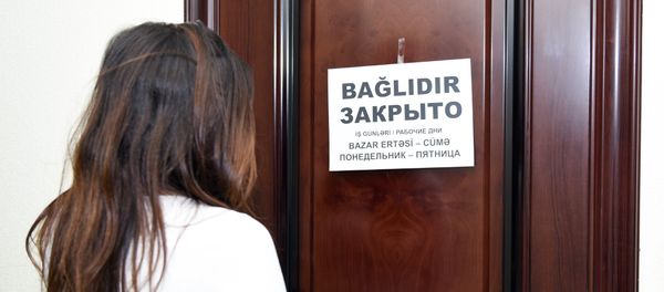 Девушка стоит у закрытой двери - Sputnik Азербайджан