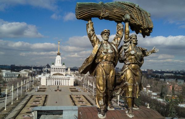 Скульптура Тракторист и колхозница на триумфальной арке Главного входа Выставки достижений народного хозяйства в Москве. На втором плане павильон №1 Центральный. - Sputnik Азербайджан