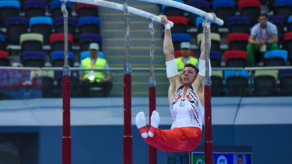 Финалы соревнований по спортивной гимнастике среди мужчин и женщин в вольных упражнениях, упражнениях на брусьях и кольцах, в опорном прыжке и на брусьях - Sputnik Азербайджан