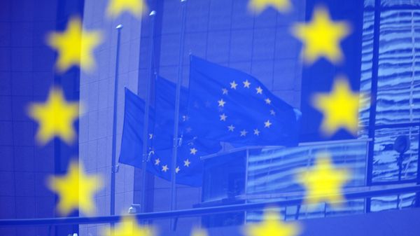 Флаги в отражении на стенде с эмблемой ЕС - Sputnik Азербайджан