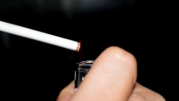 Мужчина закуривает сигарету, фото из архива - Sputnik Азербайджан