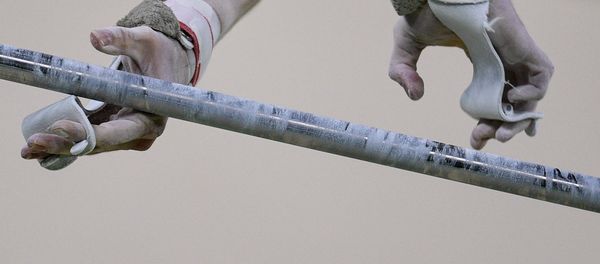 Спортсмен выполняет упражнения на перекладине на соревнованиях по спортивной гимнастике, фото из архива - Sputnik Азербайджан