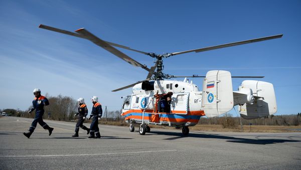 Сотрудники МЧС у вертолета Ка-32 во время учений по ликвидации последствий дорожно-транспортного происшествия на пересечении участка автодороги Великий Новгород – Нехино и объездной автодороги Луга – Шимск - Sputnik Азербайджан