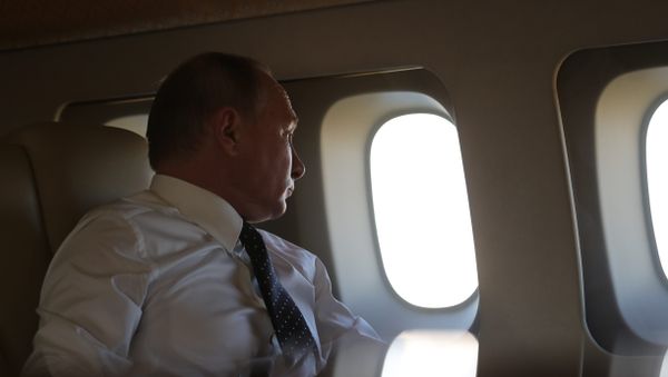 Президент РФ Владимир Путин на борту президентского самолета во время полета на авиабазу Хмеймим в Сирии - Sputnik Азербайджан