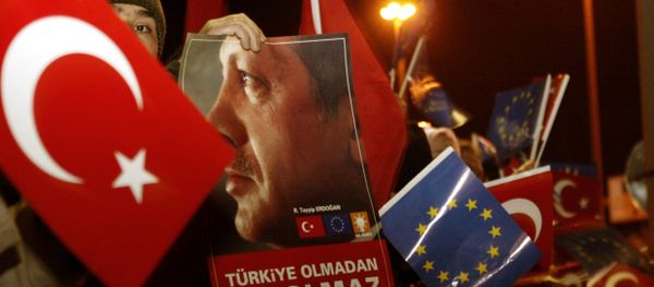 Люди с флагами Турции и с флагами ЕС, во время прибытия президента Турции Реджеп Тайип Эрдогана в международный аэропорт Ататюрка в Стамбуле, 18 декабря 2004 года - Sputnik Азербайджан