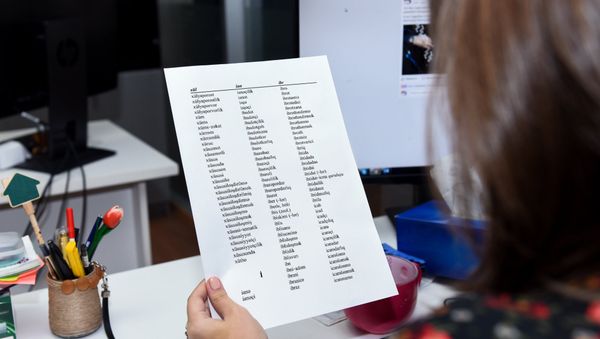 Девушка просматривает лист бумаги со списком слов, скопированных с Орфографического словаря Азербайджанского языка - Sputnik Азербайджан