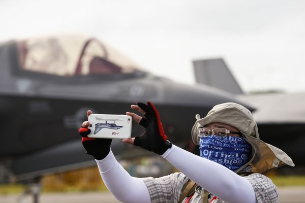 Посетитель авиашоу в Сингапуре во время фотографирования - Sputnik Азербайджан