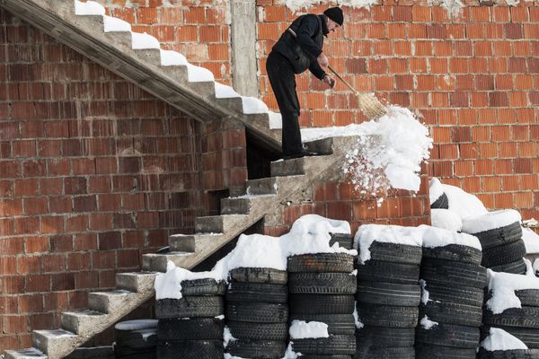 Мужчина убирает снег с лестницы дома в деревне Мрамор, Приштина, Сербия - Sputnik Азербайджан