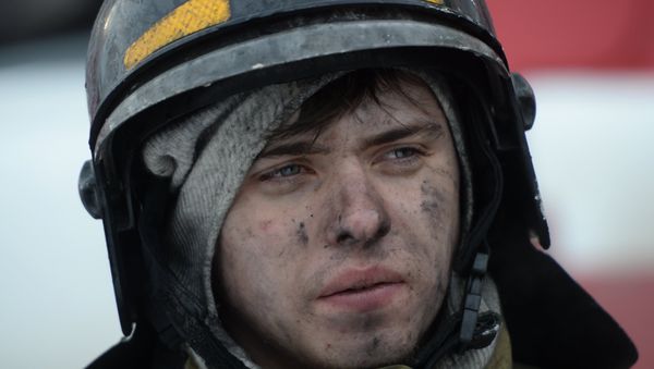 Сотрудник пожарной охраны МЧС во время тушения пожара в торговом центре Зимняя вишня в Кемерово - Sputnik Азербайджан