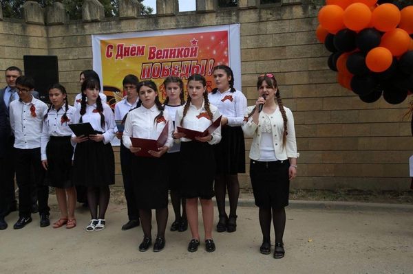 Учащиеся одной из средних школ Дербента выступают на церемонии открытия мемориальной доски капитану Шамсулле Алиеву - Sputnik Азербайджан