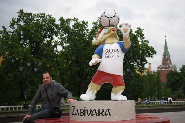 Мужчина у фигуры официального талисмана чемпионата мира по футболу 2018 волка Забиваки, установленной к чемпионату мира по футболу 2018, на Манежной площади в Москве - Sputnik Азербайджан