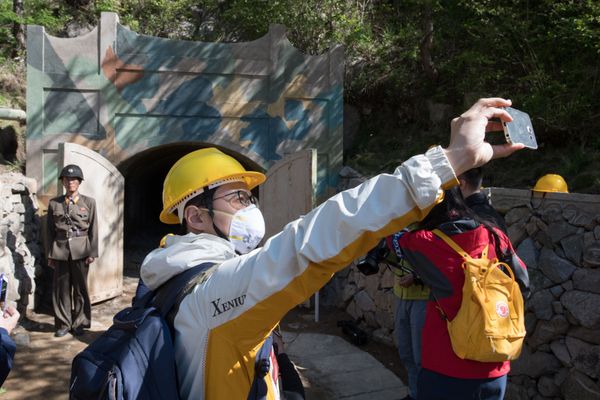 Журналисты из южной Кореи фотографируются у входа в одну из шахт во время закрытия ядерного полигона Пхунгери на севере КНДР - Sputnik Азербайджан