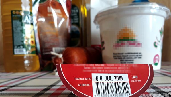 Этикетка с информацией на фоне продуктов питания, фото из архива - Sputnik Азербайджан