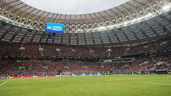 На дальнем плане на экране: решение о пенальти из-за игры рукой в финальном матче чемпионата мира по футболу между сборными Хорватии и Франции - Sputnik Азербайджан