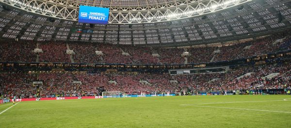 На дальнем плане на экране: решение о пенальти из-за игры рукой в финальном матче чемпионата мира по футболу между сборными Хорватии и Франции - Sputnik Азербайджан