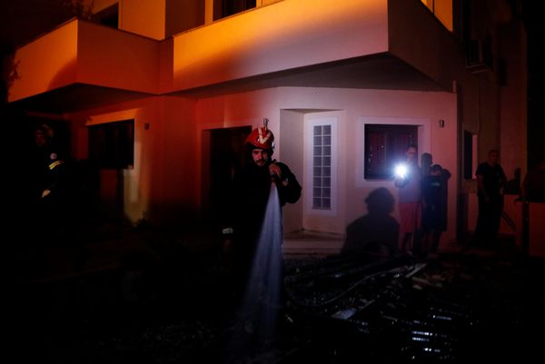 Пожарный рядом с жилым домом, попавшим в зону лесных пожаров в окрестностях Афин, Греция - Sputnik Азербайджан