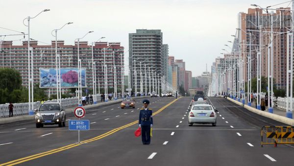 Полицейский регулирует движение на улице в Пхеньяне, Северная Корея - Sputnik Азербайджан