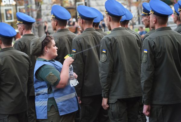 Военная медсестра охлаждает водой украинских военнослужащих во время репетиции парада в честь Дня независимости Украины в центре Киева - Sputnik Азербайджан