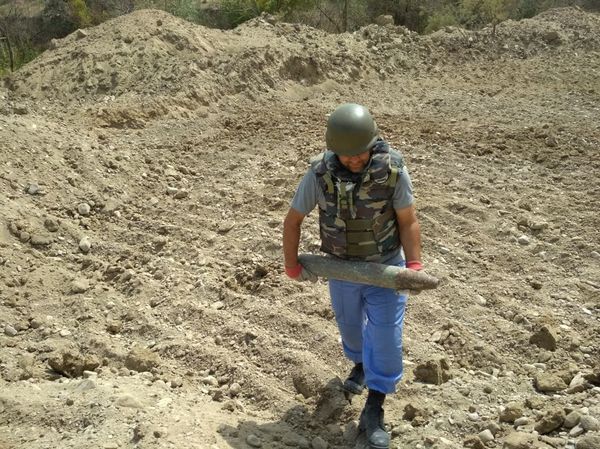 Сотрудник ANAMA на месте обезвреживания мины на территории поселка Гилязи Хызинского района - Sputnik Азербайджан
