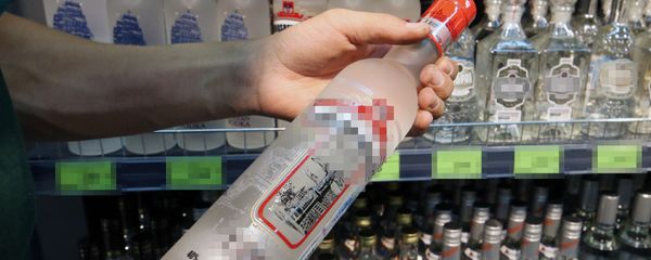 Посетитель держит бутылку водки в магазине, фото из архива - Sputnik Азербайджан