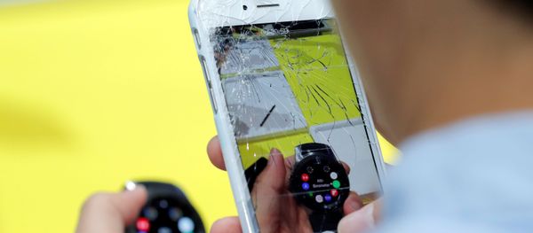 Мужчина снимает айфоном с разбитым экраном новые часы Samsung Galaxy Watch на презентации линейки новых продуктов Samsung в Бруклине - Sputnik Азербайджан