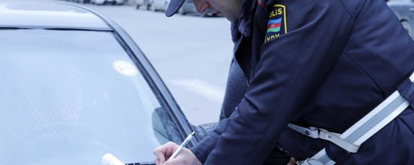 Сотрудник дорожной полиции составляет протокол об административном правонарушении, фото из архива - Sputnik Азербайджан