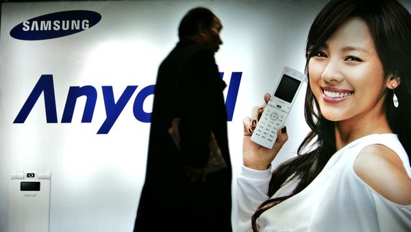 Пешеход идет мимо рекламного щита Samsung Mobile в Сеуле, Южная Корея. 2007 год - Sputnik Азербайджан