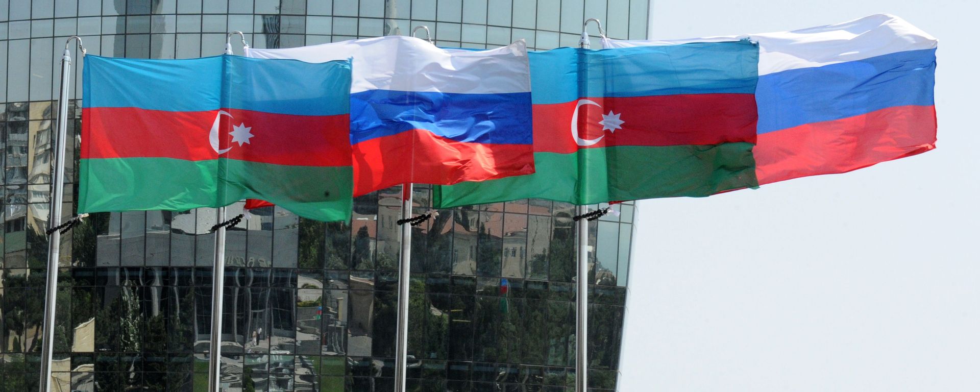 Национальные флаги России и Азербайджана на фоне фасада одной из башен Башни Пламени (Flame Towers) в Баку - Sputnik Азербайджан, 1920, 24.01.2024