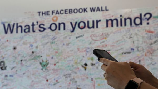 Женщина использует свой мобильный телефон в офисе Facebook в Дубае, Объединенные Арабские Эмираты, фото из архива - Sputnik Азербайджан