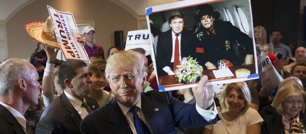 Дональд Трамп держит фотографию себя с покойным поп-певцом Майклом Джексоном - Sputnik Азербайджан