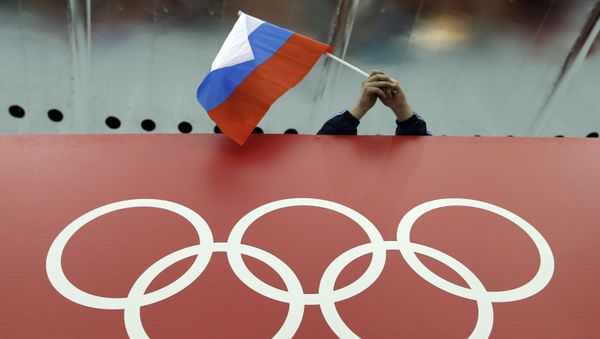 Российский фанат держит национальный флаг страны над олимпийскими кольцами - Sputnik Азербайджан