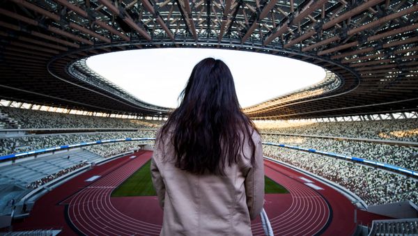 Журналист смотрит на Национальный стадион, место проведения предстоящих Олимпийских игр в Токио 2020 - Sputnik Азербайджан