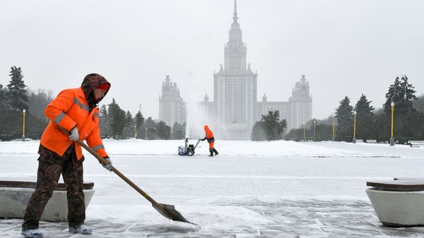 Сотрудники коммунальной службы во время уборки снега возле здания МГУ на Воробьевых горах в Москве - Sputnik Азербайджан