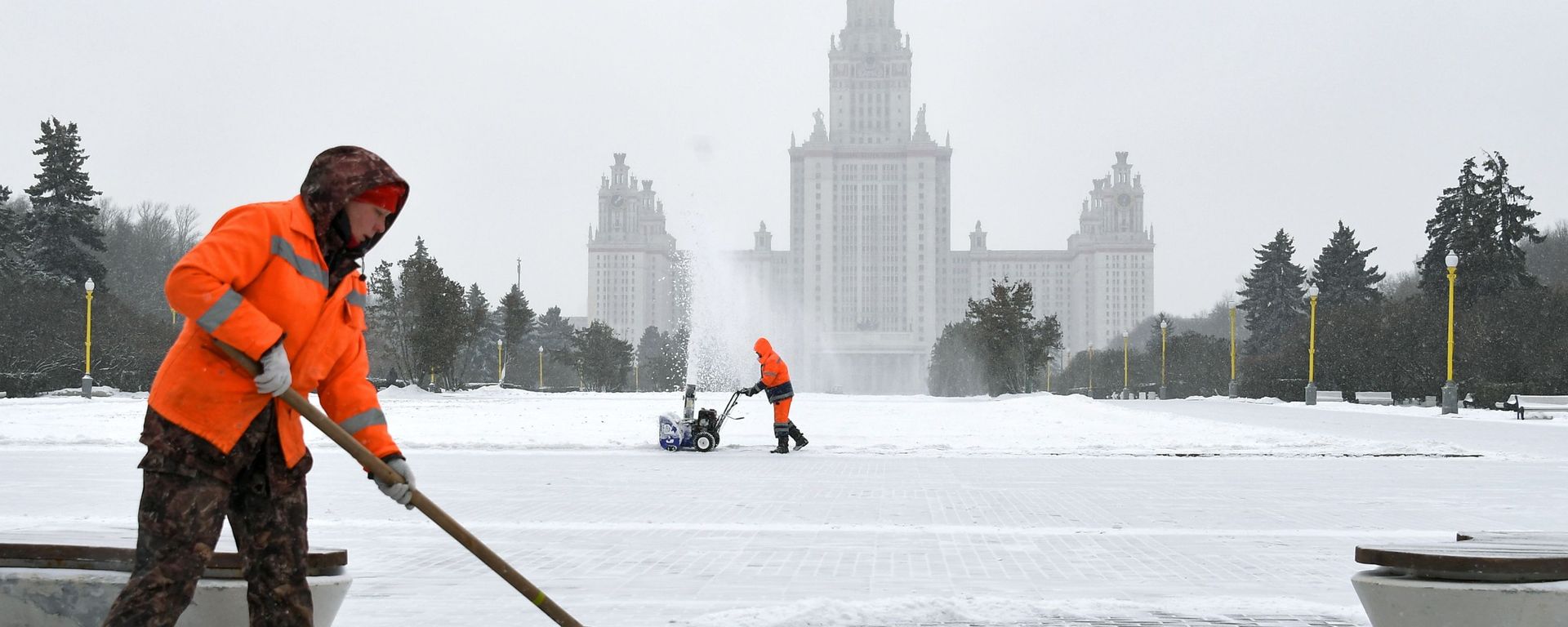 Сотрудники коммунальной службы во время уборки снега возле здания МГУ на Воробьевых горах в Москве - Sputnik Азербайджан, 1920, 10.12.2023