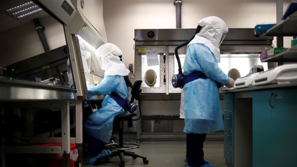 Home Team Science & Technology Agency (HTX) scientists demonstration the test process of their coronavirus test kit  - Sputnik Азербайджан