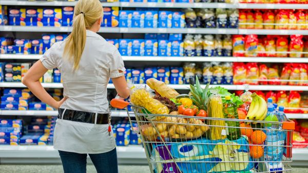 Девушка с тележкой выбирает продукты в магазине - Sputnik Азербайджан
