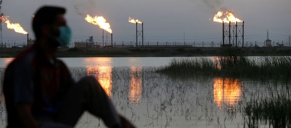 Человек в маске рядом с нефтяными качалками, фото из архива - Sputnik Азербайджан