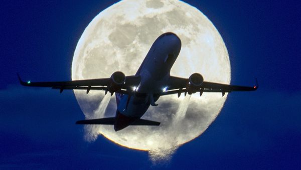 An aircraft passes the rising full moon  - Sputnik Азербайджан