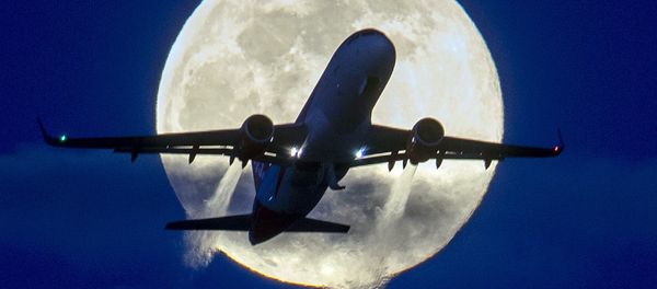 An aircraft passes the rising full moon  - Sputnik Азербайджан