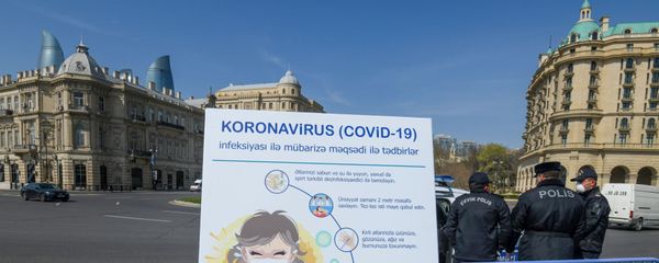Полицейские рядом с табло с надписью COVID-19 в Баку - Sputnik Азербайджан