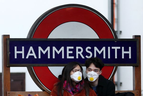 Пара в защитных масках у станции метро Hammersmith в Лондоне Пара в защитных масках у станции метро Hammersmith в Лондоне - Sputnik Азербайджан