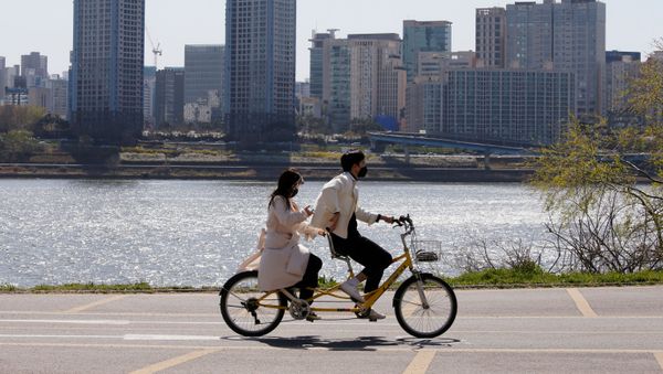 Пара в защитных масках катается на велосипеде в Сеуле, фото из архива - Sputnik Азербайджан