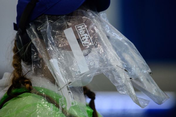 A passenger wears a face mask and plastic food bags on her face as a precautionary measure against the COVID-19 coronavirus after landing at Hong Kong’s international airport  - Sputnik Азербайджан