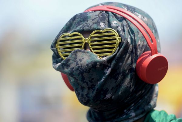 A man wearing heart-shaped glasses with his face covered amid fears of the spread of the COVID-19 novel coronavirus, stands at market during a government-imposed nationwide lockdown as a preventive measure against the COVID-19 coronavirus - Sputnik Азербайджан
