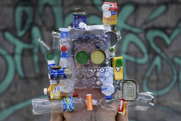 Brazilian fashion photographer Marcio Rodrigues wears a mask made with recyclable bottles, cans and boxes after over 20 days in which these garbage items were not collected because of the quarantine imposed to control the spread of the new coronavirus (COVID-19), in Belo Horizonte, Brazi - Sputnik Азербайджан