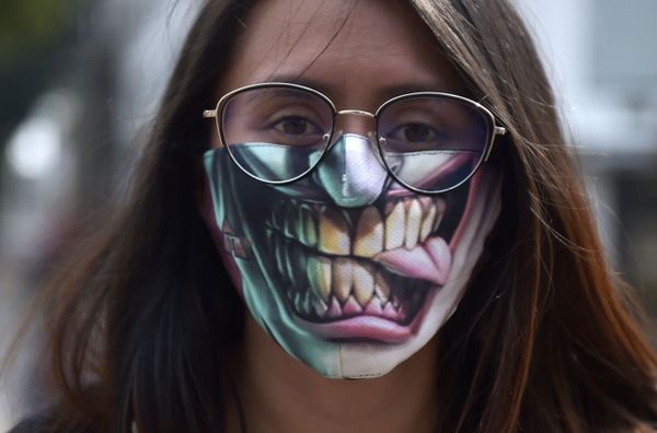 A woman uses a face masks as a preventive measure against the spread of the new coronavirus, COVID-19, in Bogota, on March 19, 2020. - Colombia - Sputnik Азербайджан