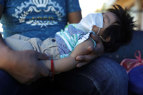 A man holds a baby wearing a protective mask during a quarantine following the outbreak of coronavirus disease (COVID-19), in Santiago, Chile, on April 1, 2020 - Sputnik Азербайджан
